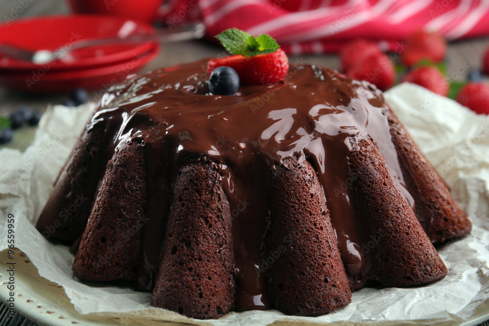 Delicious chocolate cake with berries in plate on table, closeup