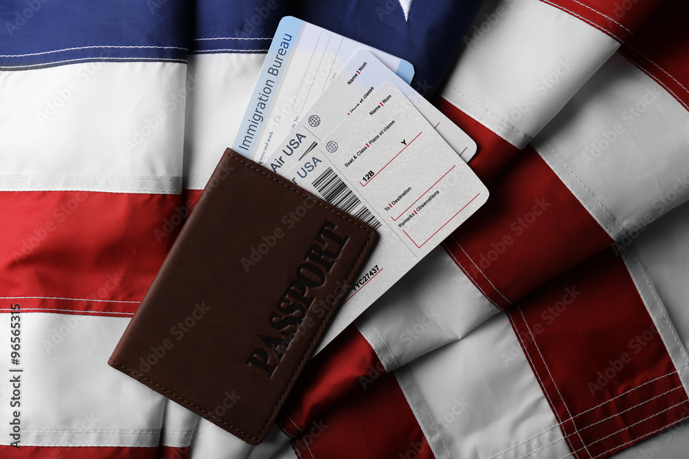 Passport, tickets lying on American Flag background