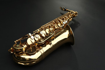 Wall Mural - Beautiful golden saxophone on black background