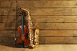 Violin and saxophone on wooden background