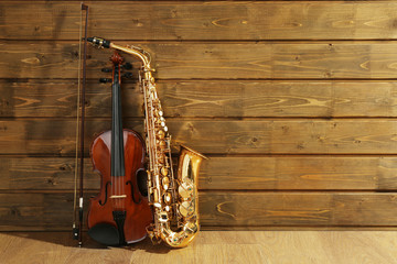 Wall Mural - Violin and saxophone on wooden background