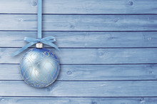 Blue Christmas Baubles With Curly Ribbon On A Blue Wooden Board With Copy Space. Simple Christmas Card.