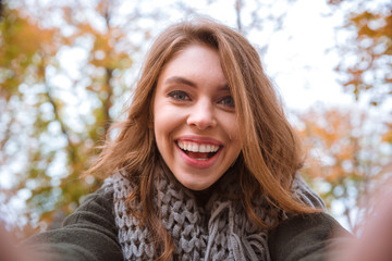 Woman making selfie photo in autumn park