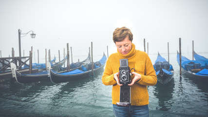 Wall Mural - Beautiful young woman photographing gondolas in Venice, Italy