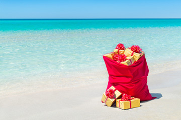 Canvas Print - Christmas sack full of wrapped gift boxes at tropical beach