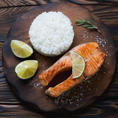 Wall Mural - Above view of fried trout steak served with rice, close-up