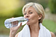 © goodluz - Senior woman drinking water after exercising