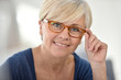 © goodluz - Portrait of smiling senior woman with eyeglasses
