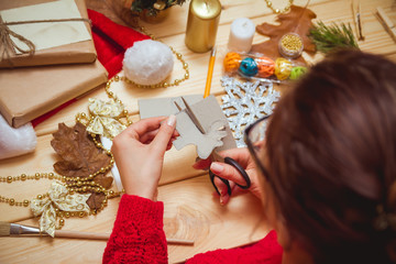 Wall Mural - The girl at the table makes Christmas gifts. Hand made