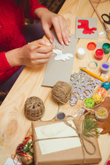 Wall Mural - The girl at the table makes Christmas gifts. Hand made