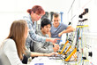 © industrieblick - Unterricht in Elektrotechnik bei der Berufsausbildung - Gruppe von Auszubildenten und einer Lehrerin // Teaching in Electrical Engineering - group of trainees and a teacher
