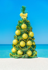 Canvas Print - Christmas tree with golden decorations at tropical ocean beach