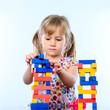 © karelnoppe - Little girl building structure with wooden blocks.