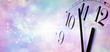 Minutes before Midnight at New Year - wide banner  with a partial clock face showing five minutes to midnight on right side with copy space on left on a misty blue and pink sparkling background