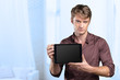 © fotofabrika - Smiling young man using tablet computer
