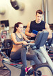 © Syda Productions - woman with trainer on exercise bike in gym