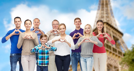 Canvas Print - people showing heart hand sign over eiffel tower