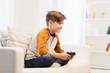 © Syda Productions - happy boy with joystick playing video game at home