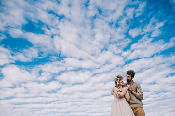 happy young couple holding hands against the sky