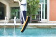 © bignai - Mna is cleaning a swimming pool with a brush