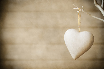 heart hanging from tree on wood background - vintage