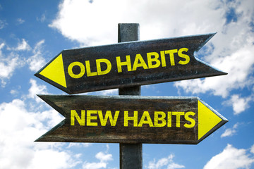 Old Habits - New Habits signpost with sky background