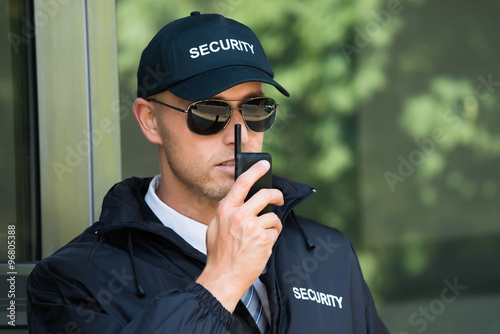 Fotografía Guardia de seguridad joven que habla en el walkie-talkie
