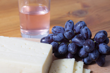 cheese and grapes on the wooden table