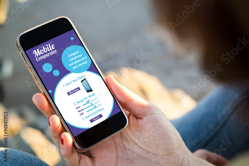 Fotografía Mujer sentada en la calle sosteniendo su teléfono inteligente con r móviles