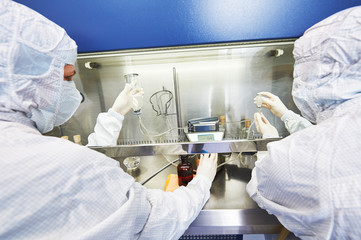 workers in protective uniform at laboratory