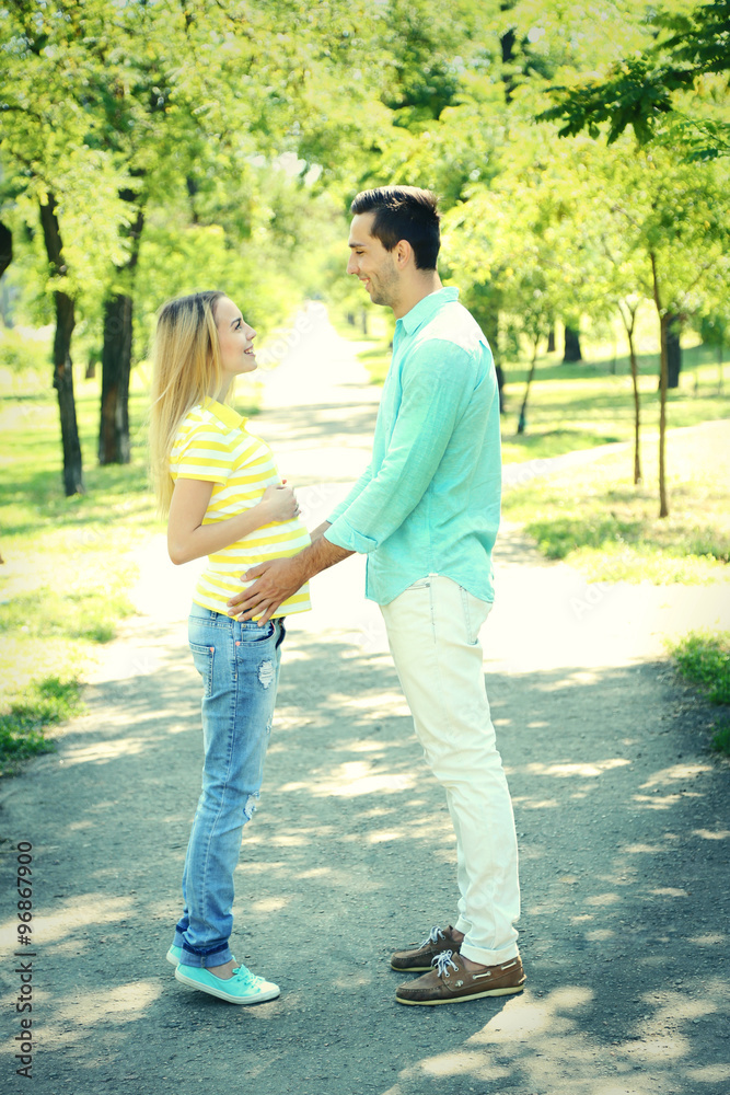 Young pregnant woman with husband in park
