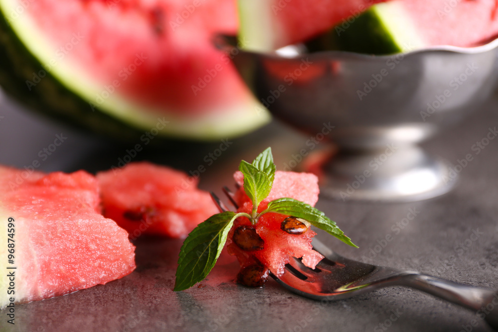 Sliced watermelon in metal bowl on grey background, close up