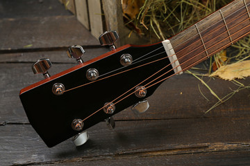 Sticker - Acoustic guitar against box with hay on wooden background,, close up