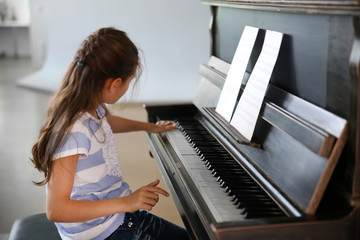 Poster - Cute little girl studding to play piano