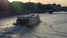 Paris, Paddlewheel Riverboat On The River Seine With Lens Flare At Sunset