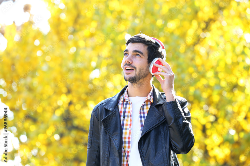 Young man in a park listening to music