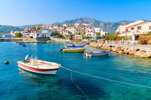 Fishing Boats In Kokkari Bay With Colourful Houses In Background, Samos Island, Greece
