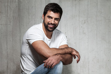 Portrait of a smiling man in a white T-shirt in the loft