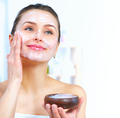 Beautiful woman applying natural facial mask