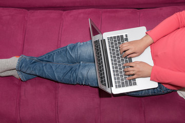 Woman sitting on the sofa using a laptop