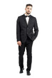 © sharplaninac - Confident young man with hands in pocket walking to camera front view. Full body length portrait isolated over white studio background.