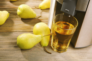 Poster - Stainless juice extractor with pears and glass of juice on wooden background, close up