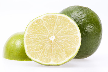 Wall Mural - pieces of fresh green fruit of lime on white background