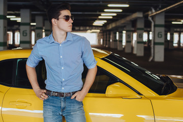 Handsome man standing near the modern sport car