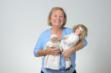 Elderly Woman Holding Two Antique Dolls
