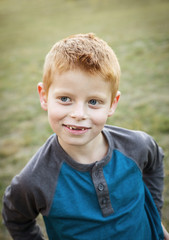 Cute and Silly Little red haired boy portrait outdoors