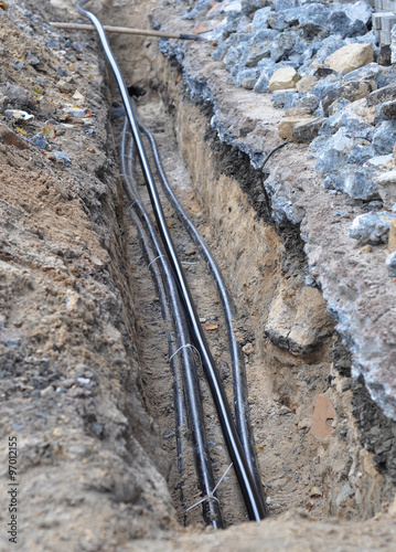 Fotografía Close up on electric cable and optical fibres in the digging on the street const