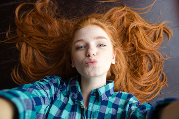 Top view of woman making selfie and sending air kiss