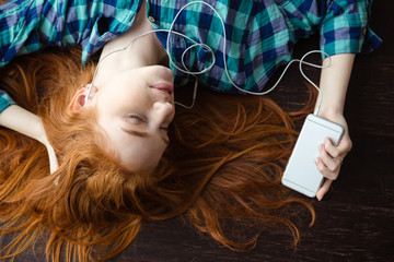 Canvas Print - Woman lying on floor and listening to music