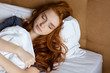 Redhead woman sleeping in the bed